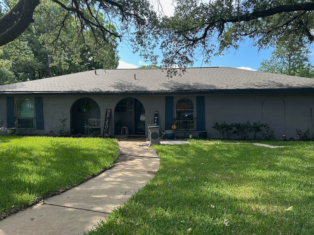1229 Surry Place Dr, Cleburne, TX 76033 - view of front facade with brick siding, a front lawn, a porch, and roof with shingles