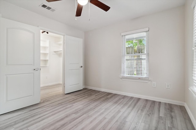 1006 Tower Dr, Cedar Hill, TX 75104 - unfurnished bedroom featuring light wood-style floors, baseboards, a spacious closet, and a ceiling fan