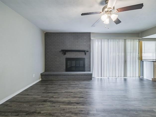 1901 Castille Dr, Carrollton, TX 75007 - unfurnished living room featuring wood finished floors, a ceiling fan, baseboards, and a fireplace