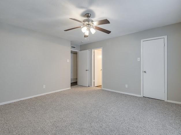 1901 Castille Dr, Carrollton, TX 75007 - unfurnished bedroom with light colored carpet, baseboards, and ceiling fan
