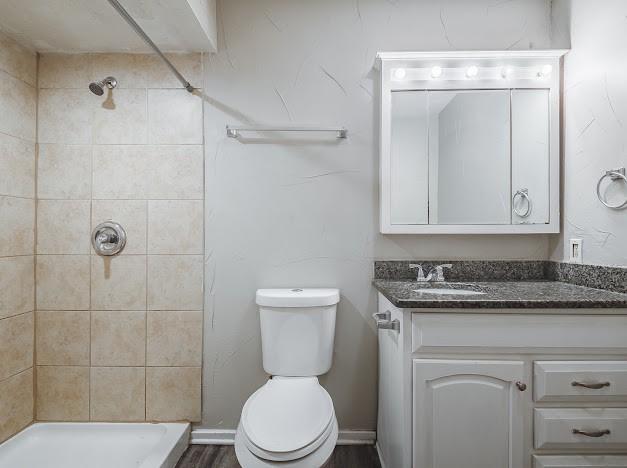 1901 Castille Dr, Carrollton, TX 75007 - bathroom with vanity, toilet, and a tile shower