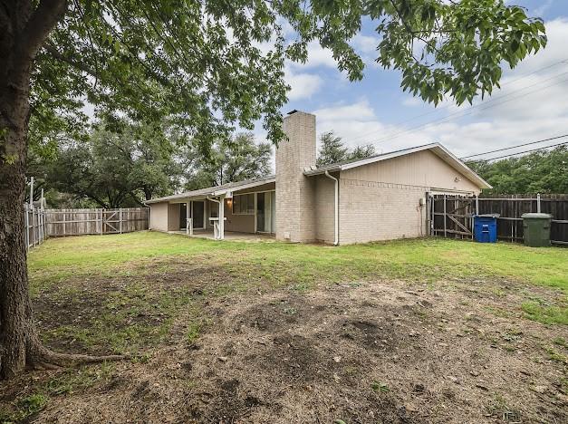 1901 Castille Dr, Carrollton, TX 75007 - rear view of house with a chimney, brick siding, and a patio