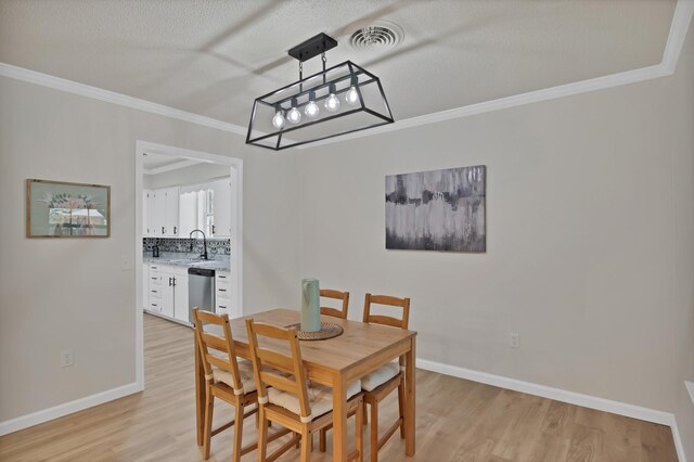 214 Bluebonnet Trl, Keene, TX 76059 - kitchen featuring stainless steel appliances, a sink, white cabinets, light wood-style floors, and ornamental molding