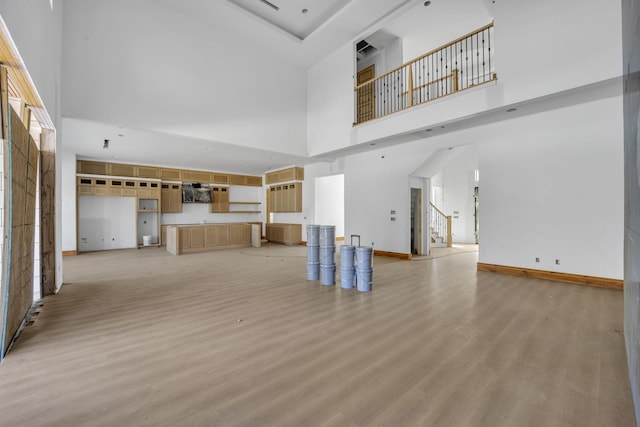 1010 W Mcdonwell School Rd, Colleyville, TX 76034 - unfurnished living room with a towering ceiling, light wood finished floors, and baseboards