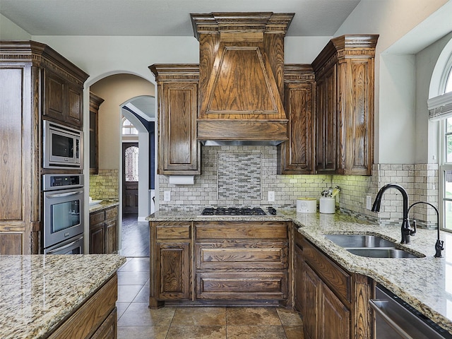 2420 Lilyfield Dr, Trophy Club, TX 76262 - kitchen featuring stainless steel appliances, ventilation hood, a sink, and light stone countertops
