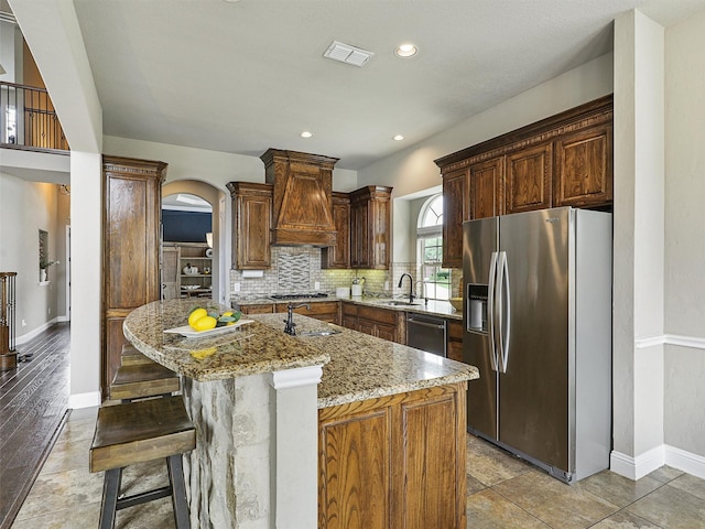 2420 Lilyfield Dr, Trophy Club, TX 76262 - kitchen featuring stainless steel appliances, custom range hood, a sink, light stone counters, and tasteful backsplash