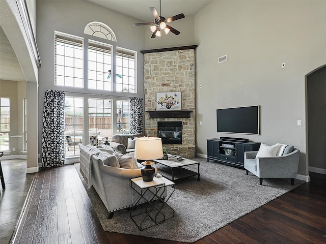 2420 Lilyfield Dr, Trophy Club, TX 76262 - living room featuring a towering ceiling, ceiling fan, hardwood / wood-style flooring, arched walkways, and a stone fireplace