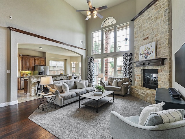 2420 Lilyfield Dr, Trophy Club, TX 76262 - living room with a ceiling fan, wood finished floors, arched walkways, a high ceiling, and a fireplace