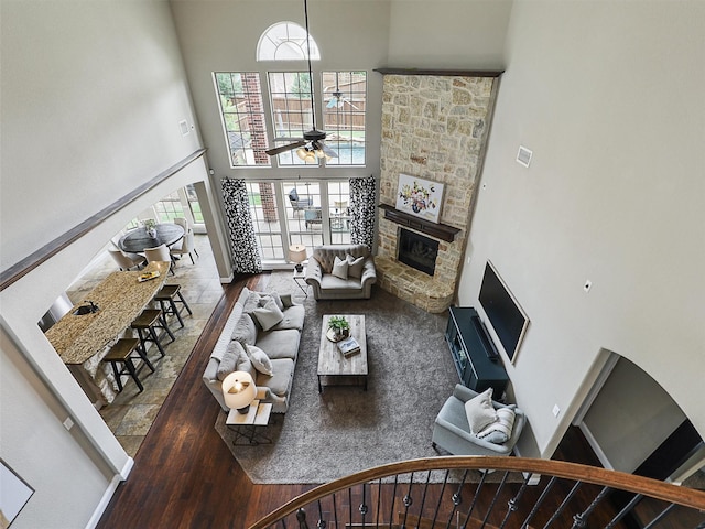 2420 Lilyfield Dr, Trophy Club, TX 76262 - living room with a towering ceiling, wood finished floors, a stone fireplace, and a ceiling fan