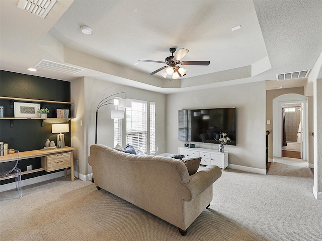 2420 Lilyfield Dr, Trophy Club, TX 76262 - living area featuring a raised ceiling, ceiling fan, arched walkways, carpet floors, and baseboards