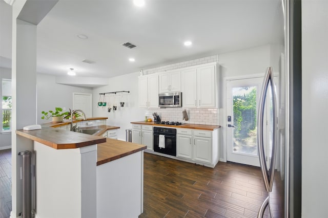 10014 Fairway Vista Dr, Rowlett, TX 75089 - kitchen featuring wooden counters, appliances with stainless steel finishes, a sink, white cabinets, and backsplash