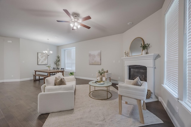 14844 Gentry Dr, Aledo, TX 76008 - living room with dark wood finished floors, a glass covered fireplace, a ceiling fan, baseboards, and a chandelier