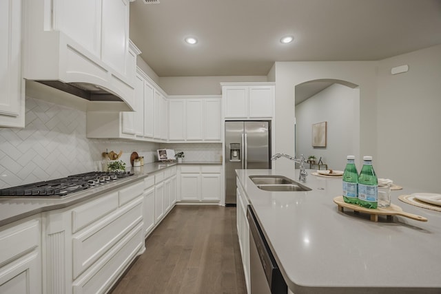 14844 Gentry Dr, Aledo, TX 76008 - kitchen featuring stainless steel appliances, a sink, arched walkways, dark wood finished floors, and white cabinetry