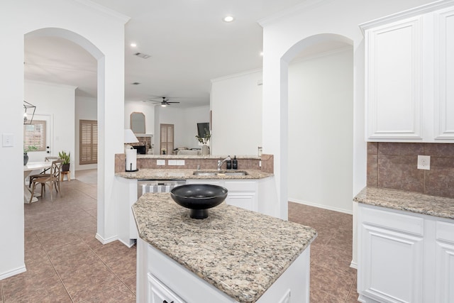 3159 Market Center Dr, Rockwall, TX 75032 - kitchen with a sink, ceiling fan, tasteful backsplash, a kitchen island, and baseboards