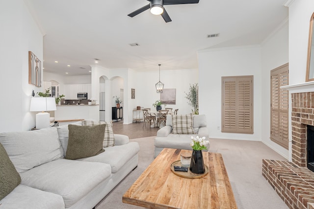 3159 Market Center Dr, Rockwall, TX 75032 - living room featuring a fireplace, ceiling fan, arched walkways, recessed lighting, and ornamental molding