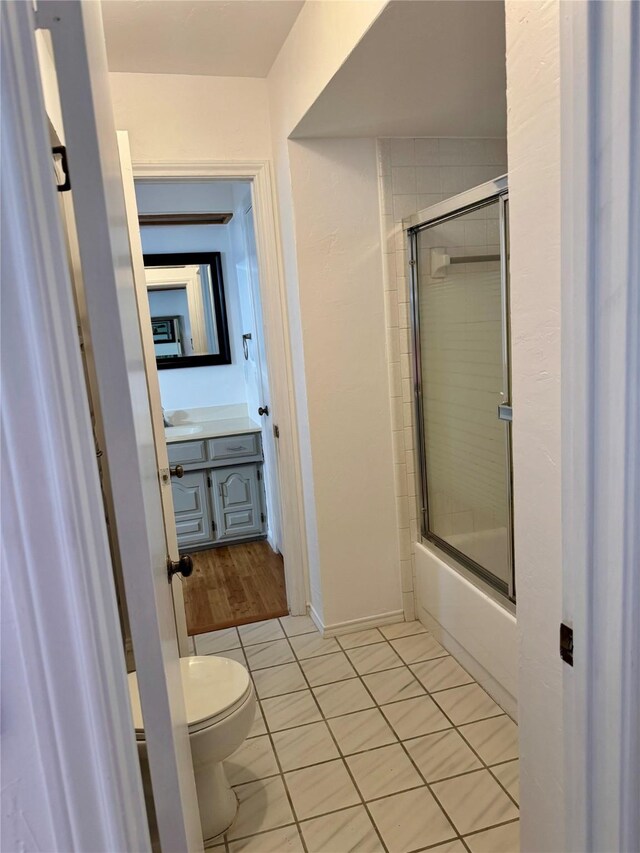 1720 Hearthstone Dr, Plano, TX 75023 - bathroom with vanity, toilet, shower / bath combination with glass door, tile patterned floors, and baseboards