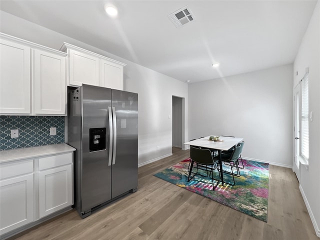 1192 Norias Dr, Forney, TX 75126 - kitchen with stainless steel fridge, white cabinets, backsplash, and light wood-style floors
