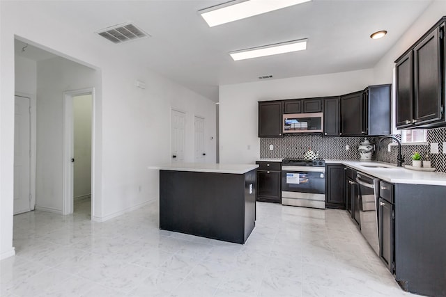 3713 Dentelle Dr, Plano, TX 75023 - kitchen featuring appliances with stainless steel finishes, a sink, tasteful backsplash, a kitchen island, and light countertops