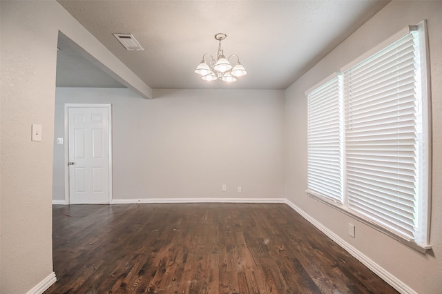 6917 Richlynn Ter, Richland Hills, TX 76118 - empty room featuring a chandelier, wood finished floors, baseboards, and healthy amount of natural light