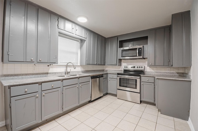 6917 Richlynn Ter, Richland Hills, TX 76118 - kitchen with stainless steel appliances, gray cabinets, a sink, and light tile patterned floors