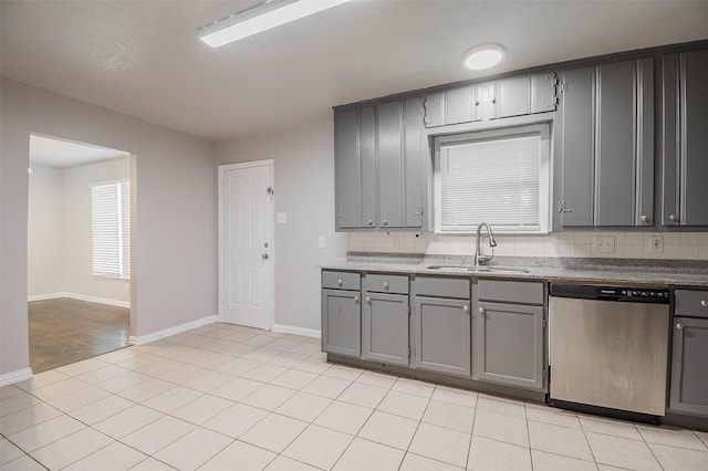 6917 Richlynn Ter, Richland Hills, TX 76118 - kitchen with stainless steel dishwasher, gray cabinets, a sink, baseboards, and light tile patterned flooring