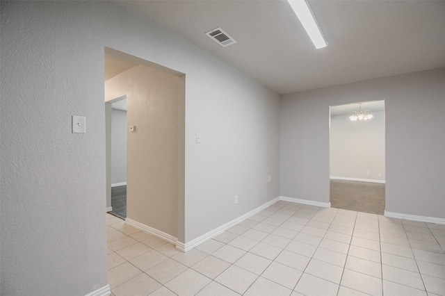 6917 Richlynn Ter, Richland Hills, TX 76118 - empty room with a chandelier, baseboards, light tile patterned floors, and a textured wall