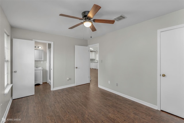 7008 Soda Point Dr, Shreveport, LA 71107 - unfurnished bedroom with dark wood-style floors, baseboards, ensuite bathroom, and ceiling fan