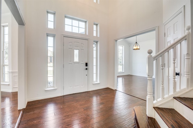 1526 Bonanza Ct, Sachse, TX 75048 - foyer entrance featuring dark wood-type flooring, stairs, and a high ceiling
