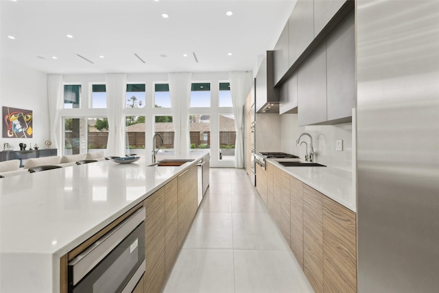 11110 Saint Michaels Dr, Dallas, TX 75230 - kitchen featuring modern cabinets, a sink, stainless steel microwave, light tile patterned floors, and recessed lighting