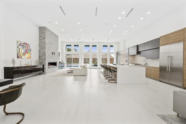 11110 Saint Michaels Dr, Dallas, TX 75230 - living area with a towering ceiling, light tile patterned flooring, recessed lighting, and a fireplace