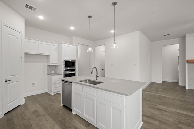1021 Allegheny Ct, Burleson, TX 76028 - kitchen with stainless steel appliances, a sink, dark wood-type flooring, white cabinetry, and recessed lighting