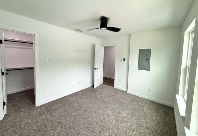1315 Oneal St, Commerce, TX 75428 - unfurnished bedroom featuring electric panel, dark colored carpet, a walk in closet, ceiling fan, and baseboards