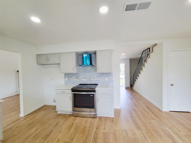 2317 Woodhollow Ave, Mesquite, TX 75150 - kitchen featuring stainless steel range oven, wall chimney range hood, tasteful backsplash, light wood-style floors, and baseboards