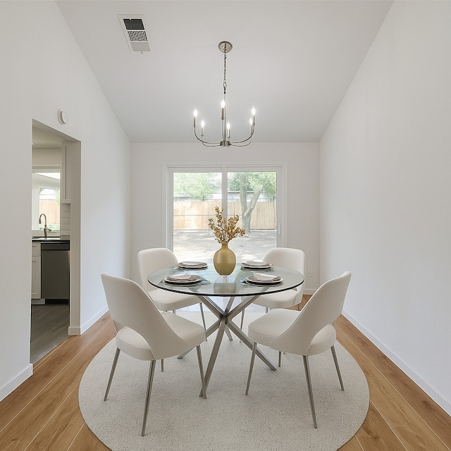 2317 Woodhollow Ave, Mesquite, TX 75150 - dining room featuring a chandelier, vaulted ceiling, light wood finished floors, and baseboards