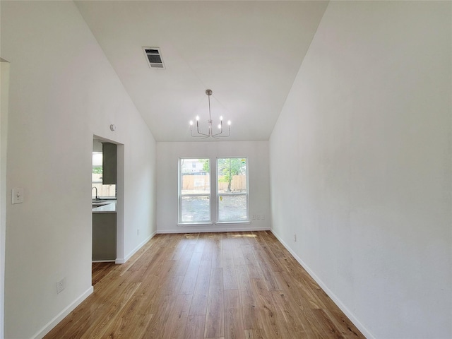 2317 Woodhollow Ave, Mesquite, TX 75150 - unfurnished living room featuring a chandelier, wood finished floors, baseboards, high vaulted ceiling, and a sink