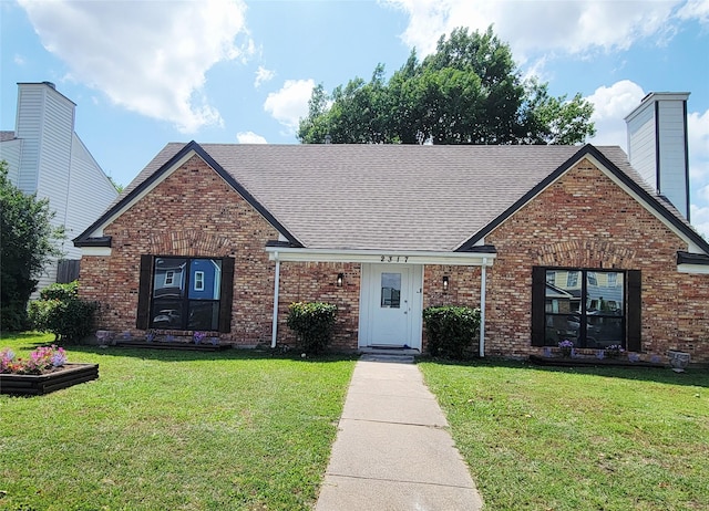 2317 Woodhollow Ave, Mesquite, TX 75150 - view of front of home with a front lawn, brick siding, a shingled roof, and a chimney