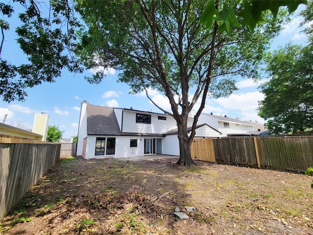 2317 Woodhollow Ave, Mesquite, TX 75150 - rear view of property with a fenced backyard, a chimney, brick siding, a shingled roof, and a patio