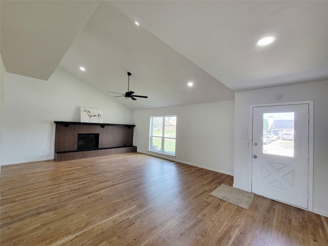 2317 Woodhollow Ave, Mesquite, TX 75150 - unfurnished living room featuring ceiling fan, light wood-style floors, vaulted ceiling, a fireplace, and baseboards