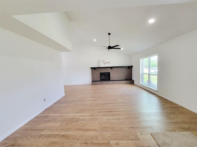 2317 Woodhollow Ave, Mesquite, TX 75150 - unfurnished living room featuring ceiling fan, a fireplace with raised hearth, light wood finished floors, lofted ceiling, and recessed lighting