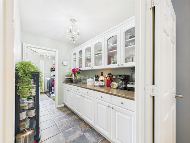 1409 Stoney Hills Dr, Cedar Hill, TX 75104 - kitchen featuring a chandelier, dark countertops, glass insert cabinets, white cabinets, and pendant lighting
