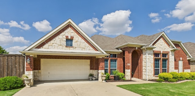 1409 Stoney Hills Dr, Cedar Hill, TX 75104 - view of front of house with stone siding, a garage, driveway, brick siding, and roof with shingles