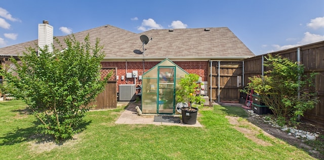 1409 Stoney Hills Dr, Cedar Hill, TX 75104 - rear view of house with a shingled roof, a chimney, central AC, and brick siding