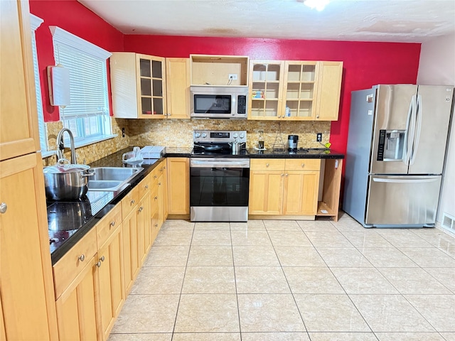 3106 Marydale Rd, Garland, TX 75041 - kitchen with appliances with stainless steel finishes, dark countertops, decorative backsplash, and light brown cabinetry