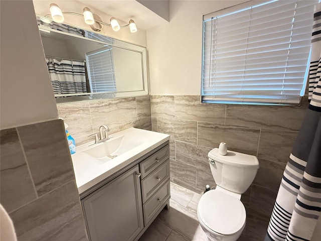 3106 Marydale Rd, Garland, TX 75041 - bathroom featuring tile walls, vanity, toilet, and a wainscoted wall