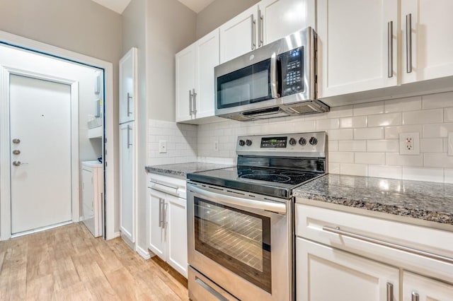 330 Las Colinas Blvd E Unit 140, Irving, TX 75039 - kitchen featuring stainless steel appliances, dark stone countertops, light wood-type flooring, and white cabinets