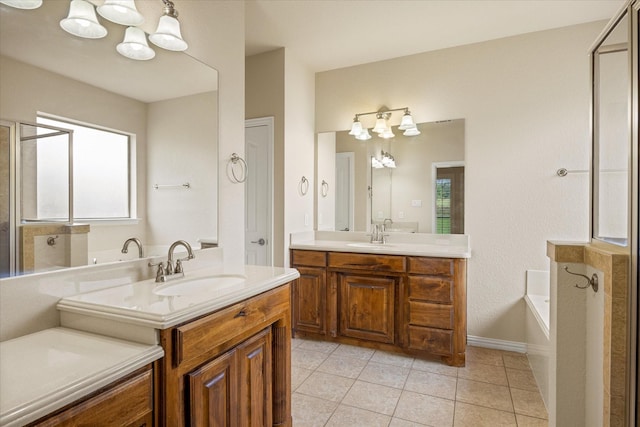 7017 Westover Dr, Granbury, TX 76049 - bathroom with two vanities, tile patterned floors, a bath, baseboards, and a chandelier