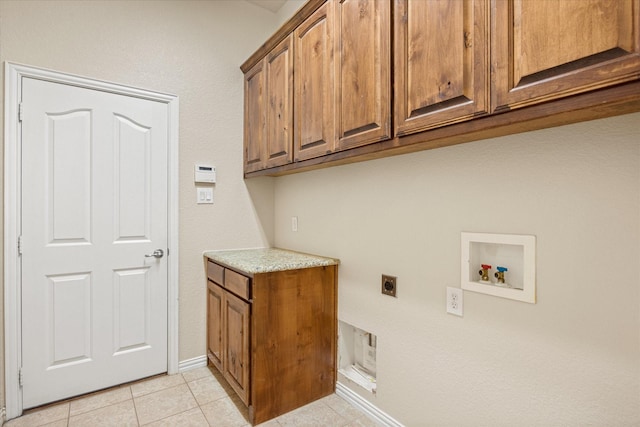 7017 Westover Dr, Granbury, TX 76049 - laundry room with cabinet space, electric dryer hookup, washer hookup, light tile patterned floors, and baseboards