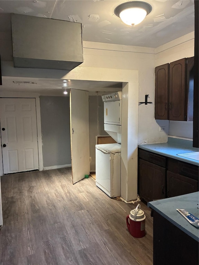 1435 Natalie St, Shreveport, LA 71108 - kitchen with stacked washer / drying machine, light wood-style floors, dark brown cabinets, light countertops, and a sink