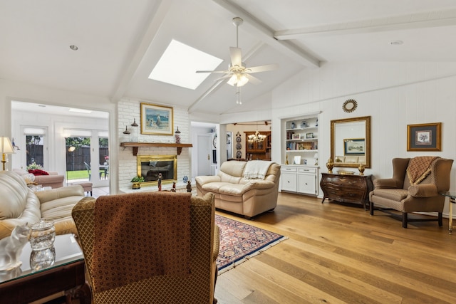 7422 Whispering Pines Dr, Dallas, TX 75248 - living area featuring light wood finished floors, a fireplace, a ceiling fan, a skylight, and built in shelves