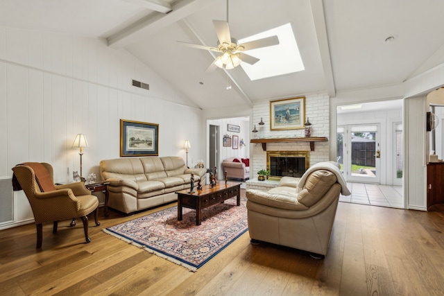 7422 Whispering Pines Dr, Dallas, TX 75248 - living area featuring hardwood / wood-style flooring, a ceiling fan, a skylight, and a brick fireplace